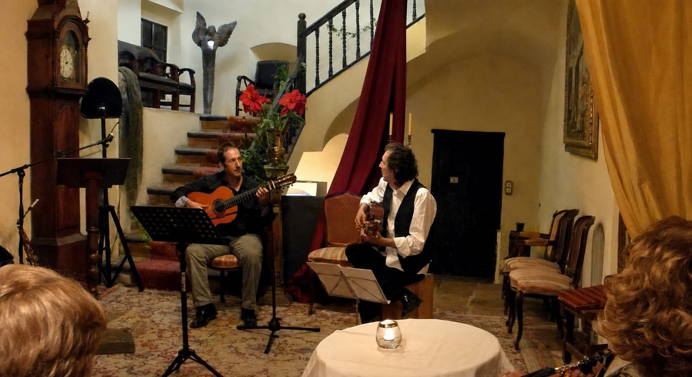 Miguel Anda y otro guitarrista en concierto en el salón de la Casa de los Alcaines, con escalera, reloj de pie y público en primer término